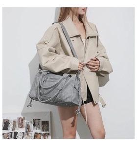 Detail of grey matte leather Boston bag with woven accents and adjustable shoulder strap