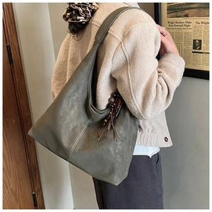 Detailed close-up of retro olive green tote bag with white stitching and wood bead charm