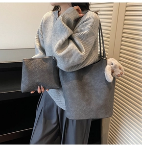 Detail of grey woven tote bag with matching pouch and plush bunny accessory charm