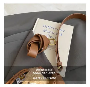 Close-up of adjustable brown leather strap with golden buckle on a vintage handbag