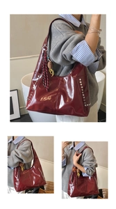 Detail of burgundy tote bag with silver studs and tassel charm decoration
