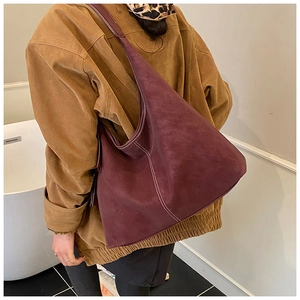 Detail of burgundy suede tote bag with white contrast stitching for winter commute