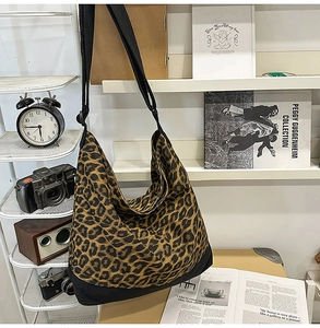 Detail of hobo bag showing leopard canvas texture and adjustable black shoulder strap