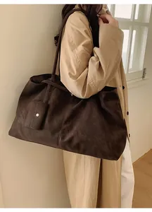 Deep brown matte tote bag with matching pouch shown on model in a minimalist style