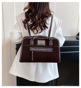 Close-up of a vintage brown suede tote bag featuring silver hardware and a front zipper pocket