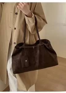 Detail of deep brown tote bag featuring long straps and a matching small coin purse attachment