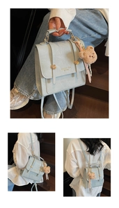 Detail of light blue crocodile-textured faux leather bag with metal buckles and bear charm