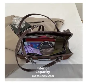 Internal capacity view of dark brown tote bag with laptop, umbrella and notebook