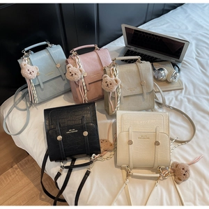 Detailed view of crocodile pattern mini backpacks in five soft colors with cute bear charms