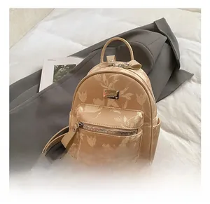 Detail of floral printed mini backpack featuring JINGPIN metal logo and zipper pocket