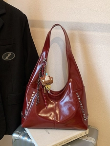 Large burgundy leather tote bag with silver studs and a teddy bear charm for women