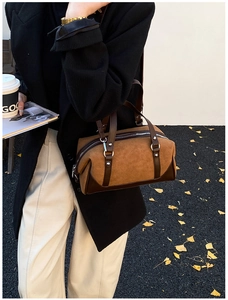 Detail of vintage brown suede Boston bag with leather trim and silver metal zipper
