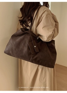 Detail of dark brown retro tote bag featuring a minimalist design and a small side pouch
