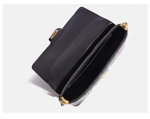 Interior view of black quilted crossbody bag showing dual compartments and gold zippers