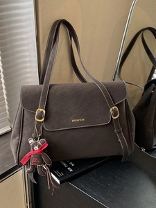 Large dark coffee tote bag with white stitching and bear charm on a dark surface
