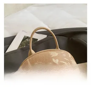 Close-up of beige backpack with floral texture and metal rivet detail in lifestyle setting