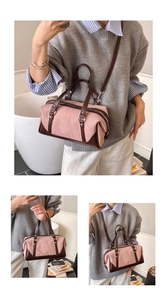 Close-up of pink canvas boston bag with brown leather handles and silver zippers