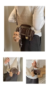Detail der dunkelbraunen Wildledertasche mit Goldnieten, Drehverschluss und Bärenanhänger