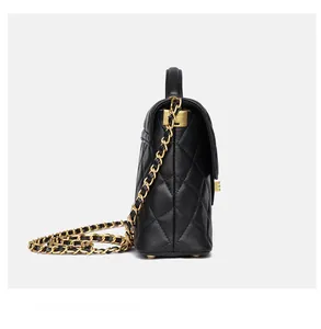 Side view detail of black quilted leather handbag with gold chain strap and stitching