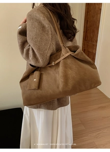 Close-up of minimalist retro tote bag in coffee leather shown on model for capacity