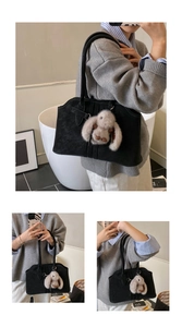 Detail of black suede tote bag with stylish vertical pleats and soft plush bunny charm