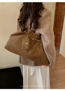 Detail of a large vintage brown suede tote bag styled with a minimalist retro vibe