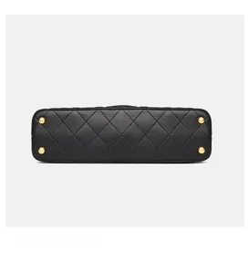 Detail view of black quilted leather bag base with four protective gold metal studs