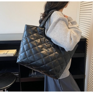 Détail du grand sac cabas noir matelassé avec plaque métallique JINGPIN et texture en PU