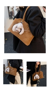 Close-up of brown suede tote bag with cross-straps and a white plush bunny charm