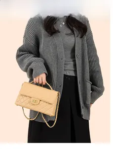 Close-up of beige quilted crossbody bag with gold-tone hardware and leather chain strap
