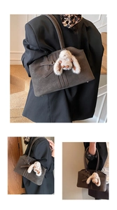 Detail of vintage suede tote bag with decorative buckle and plush rabbit charm