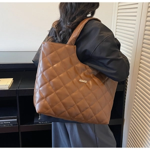 Vue détaillée du sac cabas matelassé marron avec motif en losanges et logo métallique