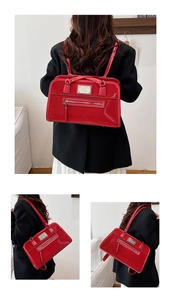 Detail view of glossy red faux leather backpack with metallic plate and zipper pocket