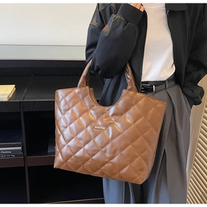 Gros plan d'un sac cabas en cuir matelassé marron avec surpiqûres en losange