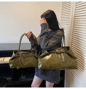 Detailed comparison of two deep green glossy leather tote bags in medium and large sizes