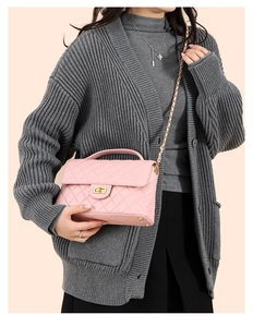 Detail of pink quilted leather shoulder bag with gold twist lock and chain strap