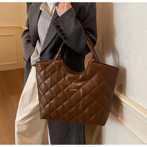 Détail du sac cabas matelassé marron en similicuir avec coutures fines et logo en métal