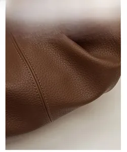 Macro detail of brown lychee grain leather with durable double-stitched sewing finish