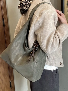 Retro olive green frosted suede large tote bag with tassel charm on model shoulder