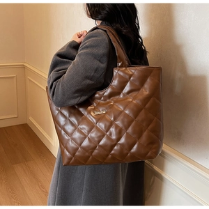 Vue détaillée du sac cabas matelassé marron avec surpiqûres losanges et plaque dorée