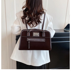 Detail view of dark brown matte tote bag with contrast stitching and silver metal hardware