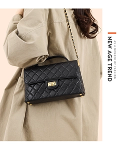 Close-up of quilted black crossbody bag with gold chain strap and metal turn-lock