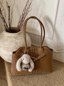 Vintage brown suede tote bag with plush rabbit charm and rustic aesthetic for autumn
