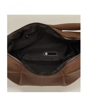 Interior view of the brown leather bag featuring a black lining and zip pocket