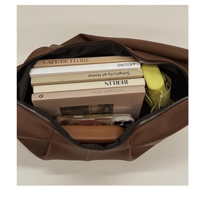 Internal view of brown leather hobo bag showing spacious capacity for books and umbrella