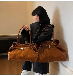 Detail of two-piece brown glossy leather tote bags with adjustable buckle straps