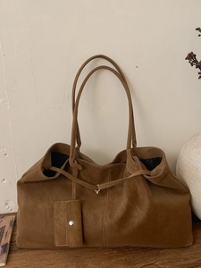 Vintage brown suede tote bag with long straps and mini pouch on wooden table