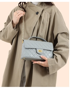 Close-up of quilted light blue handbag with gold twist lock and metal chain strap
