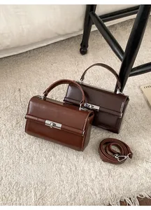 Detail view of vintage leather handbags in brown and coffee with metal turn-lock closures