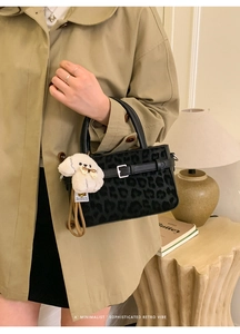 Détail du sac à main imprimé léopard avec boucle en métal et breloque chiot en peluche